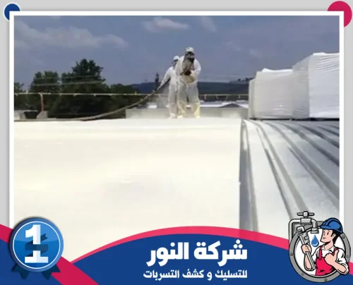 شركة عزل اسطح وخزانات بالجبيل 0546824999 النور عمال يرشون مادة عزل بيضاء على سطح واسع ضمن مرحلة تنفيذ ميدانية