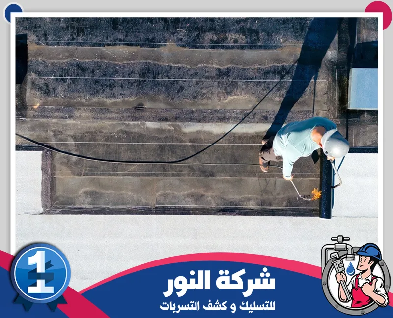 عزل حراري للاسطح بعرعر 0546824999 شركة النور للتسليك عامل يقوم بتطبيق طبقة عزل على سطح المبنى لحمايته من تسربات المياه.
