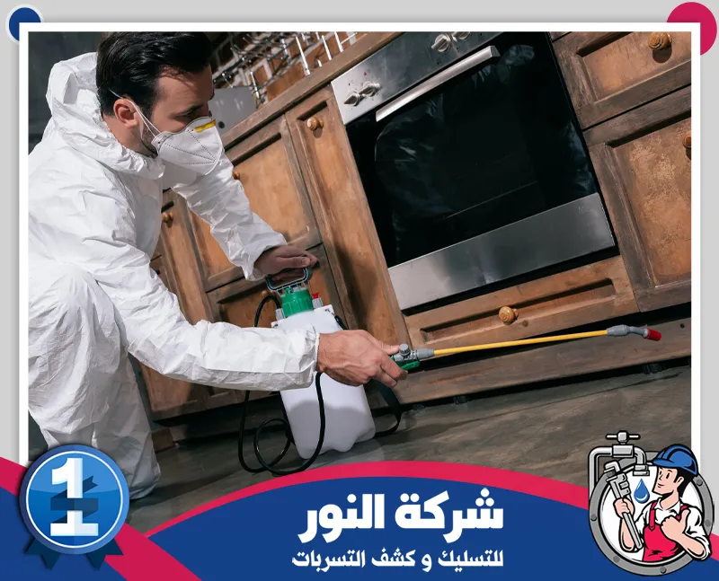 شركة مكافحة صراصير بالخفجي | شركة النور معالجة زوايا المطبخ وأماكن اختباء الحشرات برش المبيدات، مع ارتداء الفني معدات الوقاية.